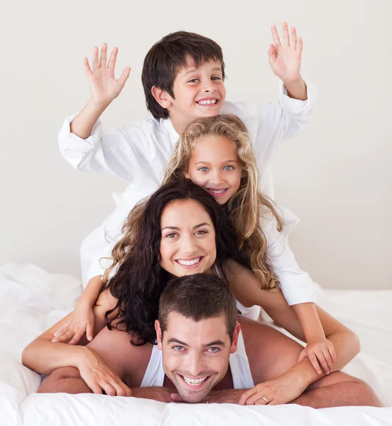 Щаслива сім'я лежить на своєму ліжку — стокове фото