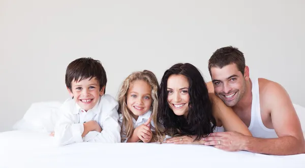 Šťastná rodina, ležící na posteli — Stock fotografie