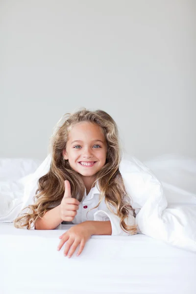 Porträt eines süßen Mädchens, das auf einem Bett liegt — Stockfoto