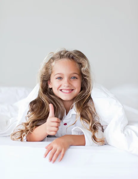 Porträt eines süßen Mädchens, das auf einem Bett liegt — Stockfoto