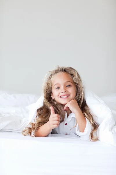 Portret van een mooi schattig meisje liggend op een bed — Stockfoto