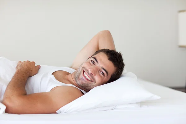 Jóképű férfi alszik egy ágyban — Stock Fotó