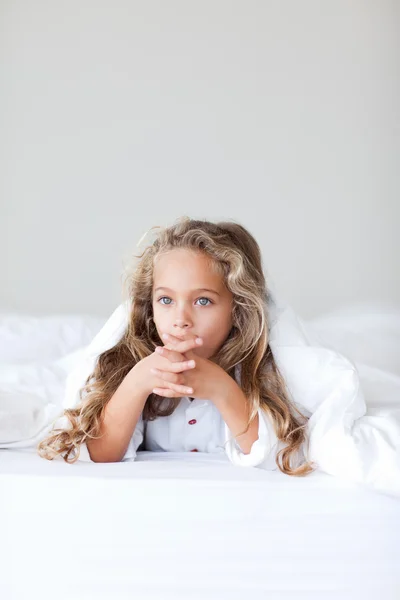 Mooi meisje op haar bed — Stockfoto