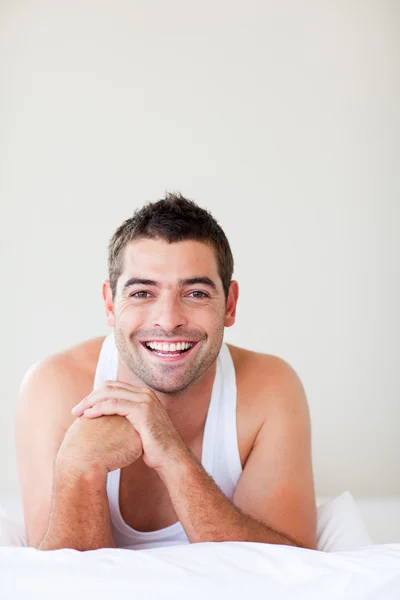 Muž v posteli úsměv do kamery — Stock fotografie