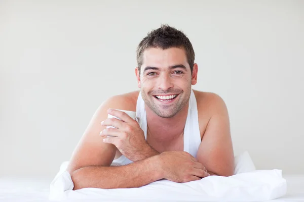 Homem tomando uma xícara de café na cama — Fotografia de Stock