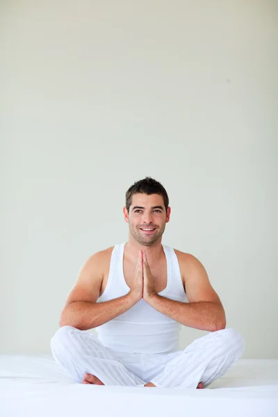 Young man meditating in bed with copy-space — Stock Photo, Image