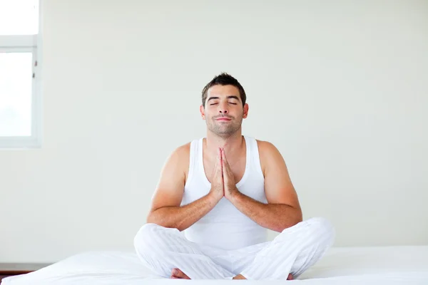 Muž sedí na posteli, meditace s clossed očima — Stock fotografie