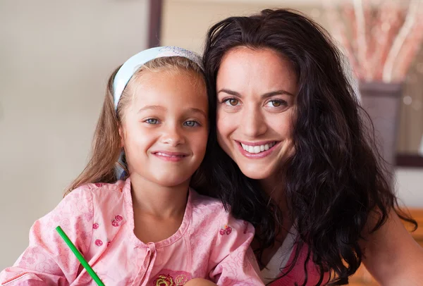 Happy mother helping her daughter for homework — Stock Photo, Image