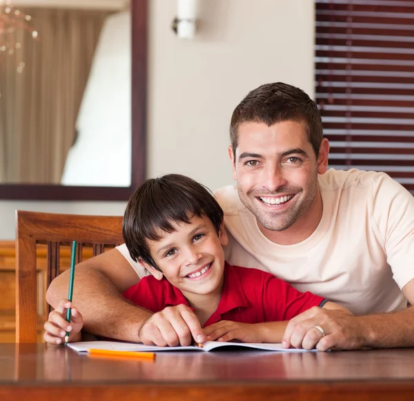 Selbstbewusster Vater hilft seinem Sohn bei den Hausaufgaben — Stockfoto