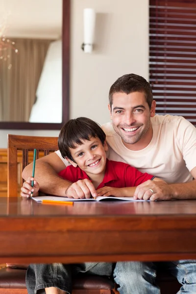 Впевнений батько допомагає своєму синові на домашнє завдання — стокове фото