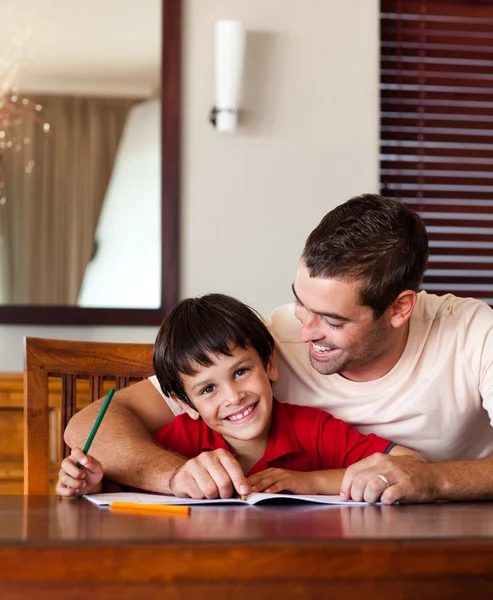 Selbstbewusster Vater hilft seinem Sohn bei den Hausaufgaben — Stockfoto