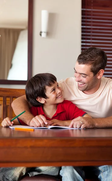 Padre fiducioso che aiuta suo figlio per i compiti — Foto Stock