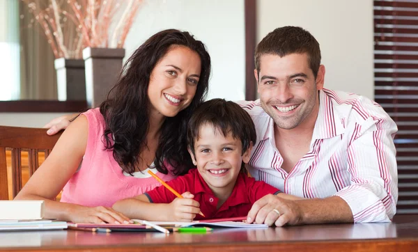 Schönes Paar hilft seinem Sohn bei den Hausaufgaben — Stockfoto