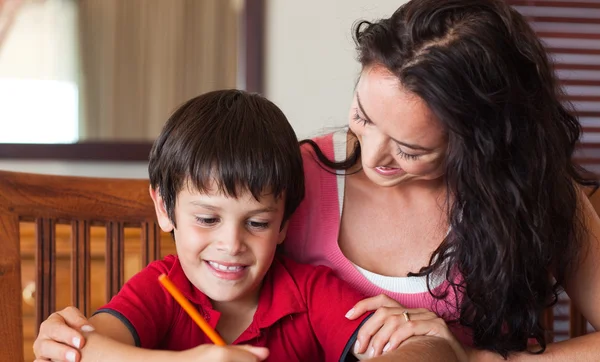 快乐妈妈帮助他的儿子的家庭作业 — 图库照片