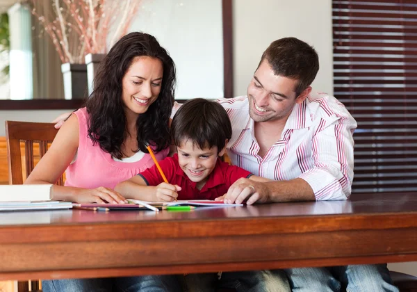 Strahlendes Paar hilft seinem Sohn bei den Hausaufgaben — Stockfoto