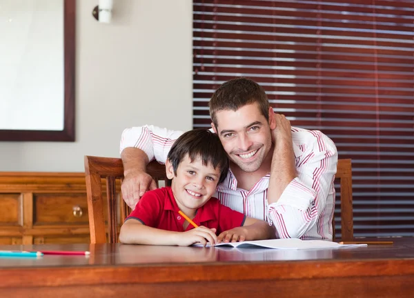 Leuke vader zoon voor huiswerk te helpen — Stockfoto