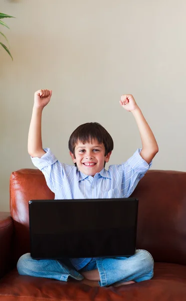 Criança feliz brincando com seu laptop — Fotografia de Stock