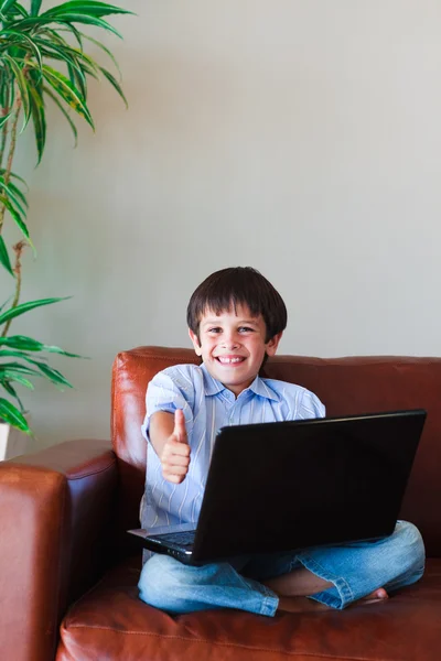 Kid using his laptop with thumb up — Stock Photo, Image