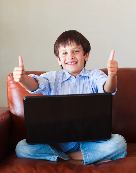 Niño jugando con su portátil con los pulgares hacia arriba — Foto de Stock