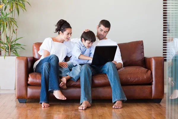 Föräldrar och son leker med en bärbar dator — Stockfoto