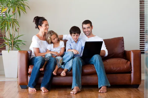 Familj spelar tillsammans med en bärbar dator — Stockfoto