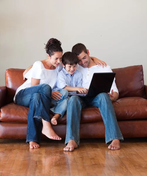 Padres e hijo jugando con un portátil — Foto de Stock