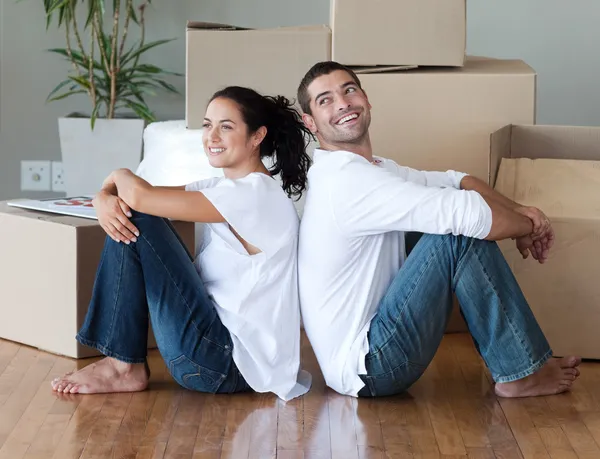 Bella coppia con scatole di disimballaggio trasferirsi in una nuova casa — Foto Stock