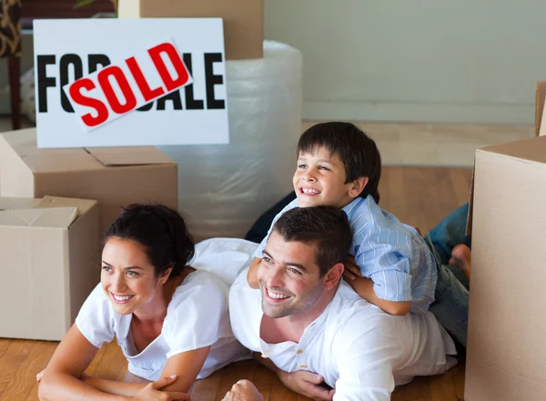 Familie kauft neues Haus auf dem Boden liegend — Stockfoto