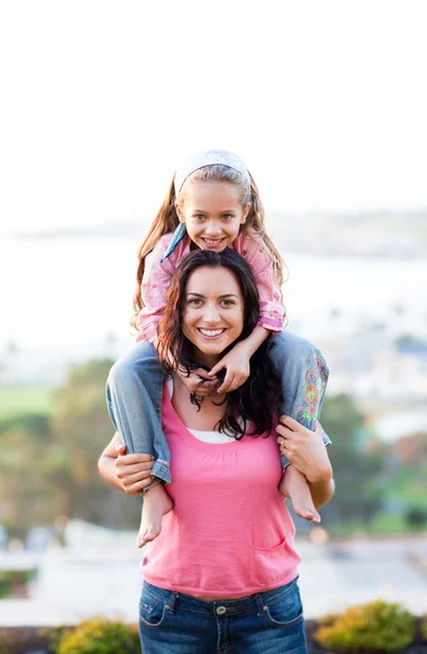 Matka dává dcera na záda — Stock fotografie