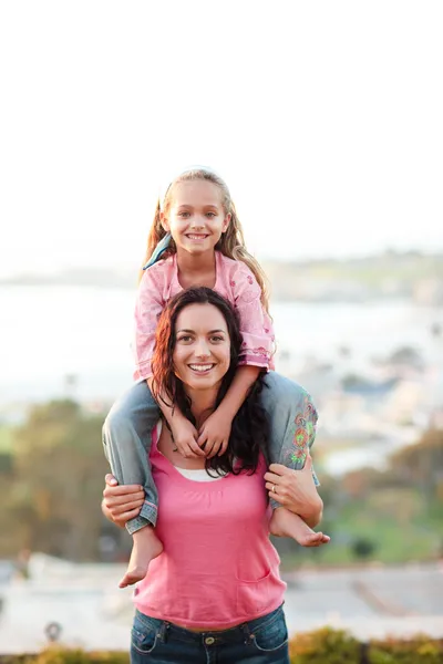 Mother giving her daughter piggyback — Stock Photo, Image