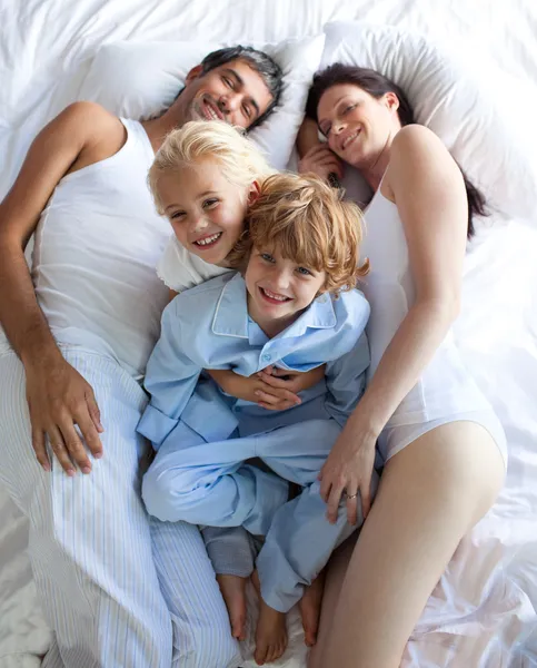 Счастливые родители и дети вместе на кровати — стоковое фото