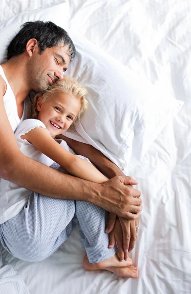 Father and daughter relaxing on bed — Stockfoto