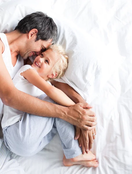 Vader huggling haar dochter op bed — Stockfoto