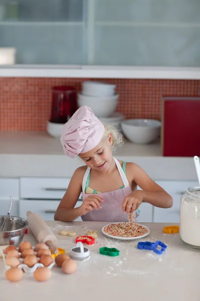 Leuke dochter bakken in een keuken — Stockfoto