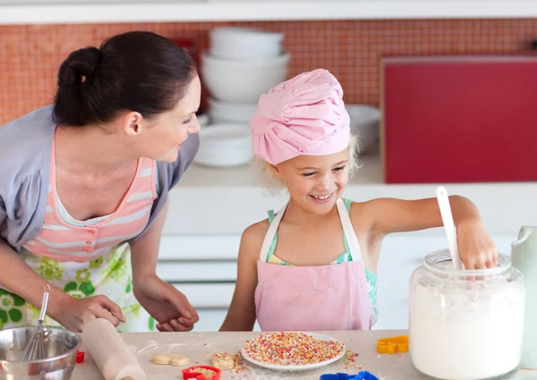 Schöne Mutter und ihre Tochter backen in einer Küche — Stockfoto