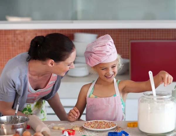 Lovely mother and her daughter baking in a kitchen — Stock Photo, Image