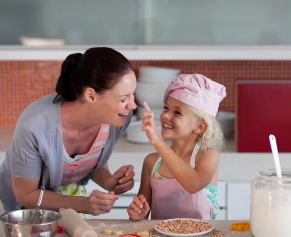 Mooie moeder en haar dochter bakken in een keuken — Stockfoto