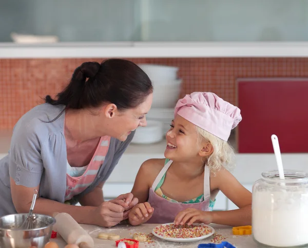 Adorável mãe e sua filha assar em uma cozinha — Fotografia de Stock