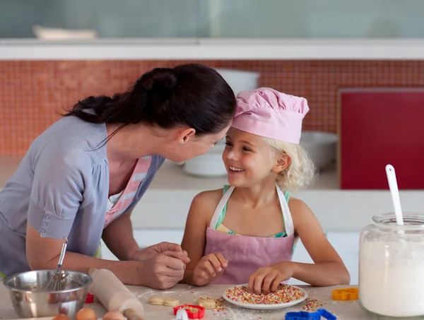 Mooie moeder en haar dochter bakken in een keuken — Stockfoto