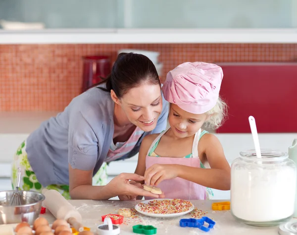 Härlig mor och hennes dotter bakning i köket — Stockfoto