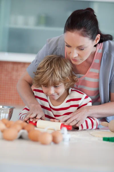 Mooi moeder en zoon bakken in een keuken — Stockfoto