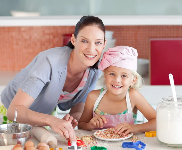 Schöne Mutter und ihre Tochter backen in einer Küche — Stockfoto