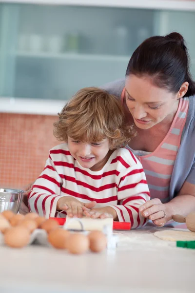 Smiling mother baking at ome with her son — Stock Photo, Image
