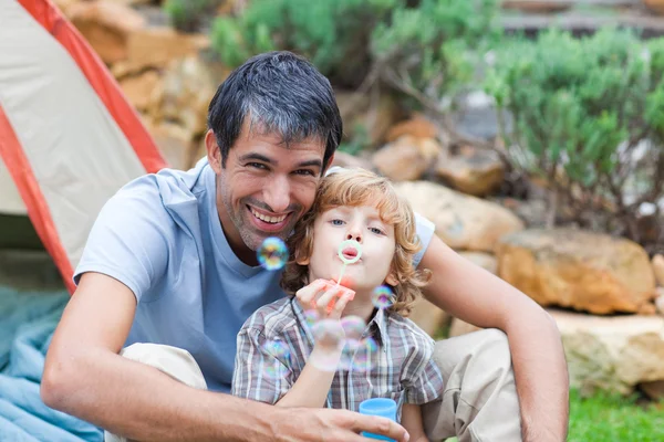 Father and son blowing bubbles — Stock Photo, Image