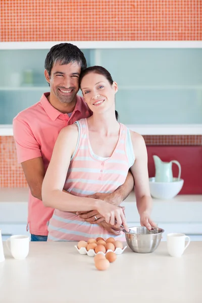 Feliz pareja cocinando juntos mirando a la cámara — Foto de Stock