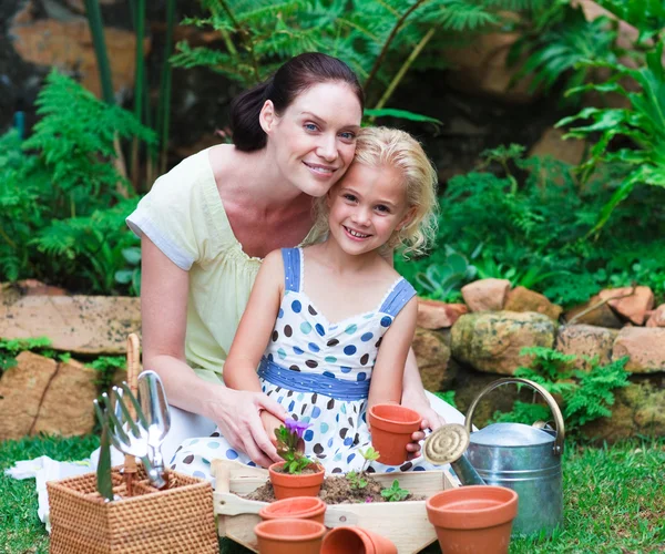 母亲和女儿在自己的花园里种植 — 图库照片