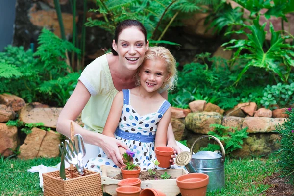 Jonge moeder en dochter planten van bloemen — Stockfoto