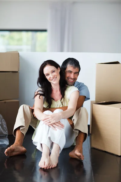 Uśmiechający się para siedzi w ich nowy dom — Zdjęcie stockowe