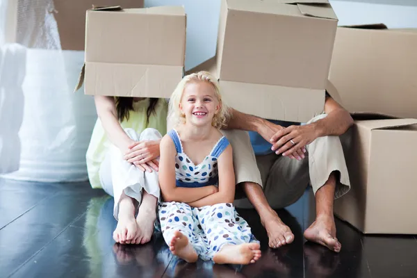Padres e hija jugando en casa con cajas —  Fotos de Stock