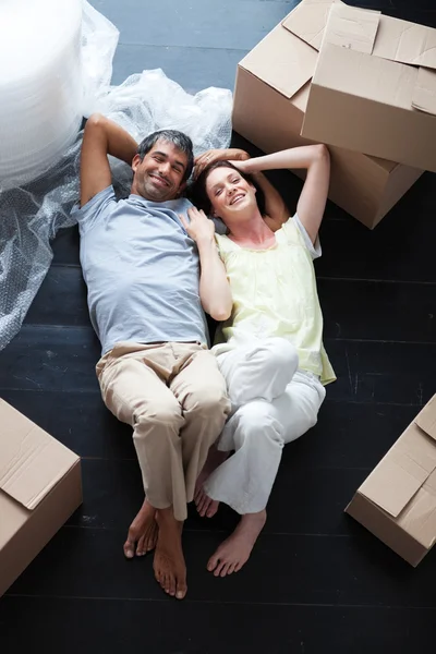 Lyckliga par avkopplande i deras nya hus — Stockfoto